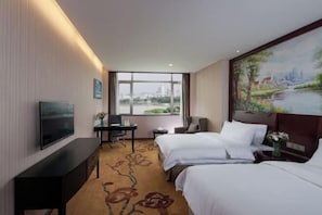 A hotel room with two beds, a desk, a TV, and a large window with a city view. - Vienna International Hotel (Shantou Chenghai Waisha Bridge) (Shantou)