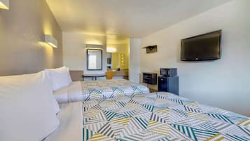 Una habitación de hotel con cama, televisión, escritorio y espejo.