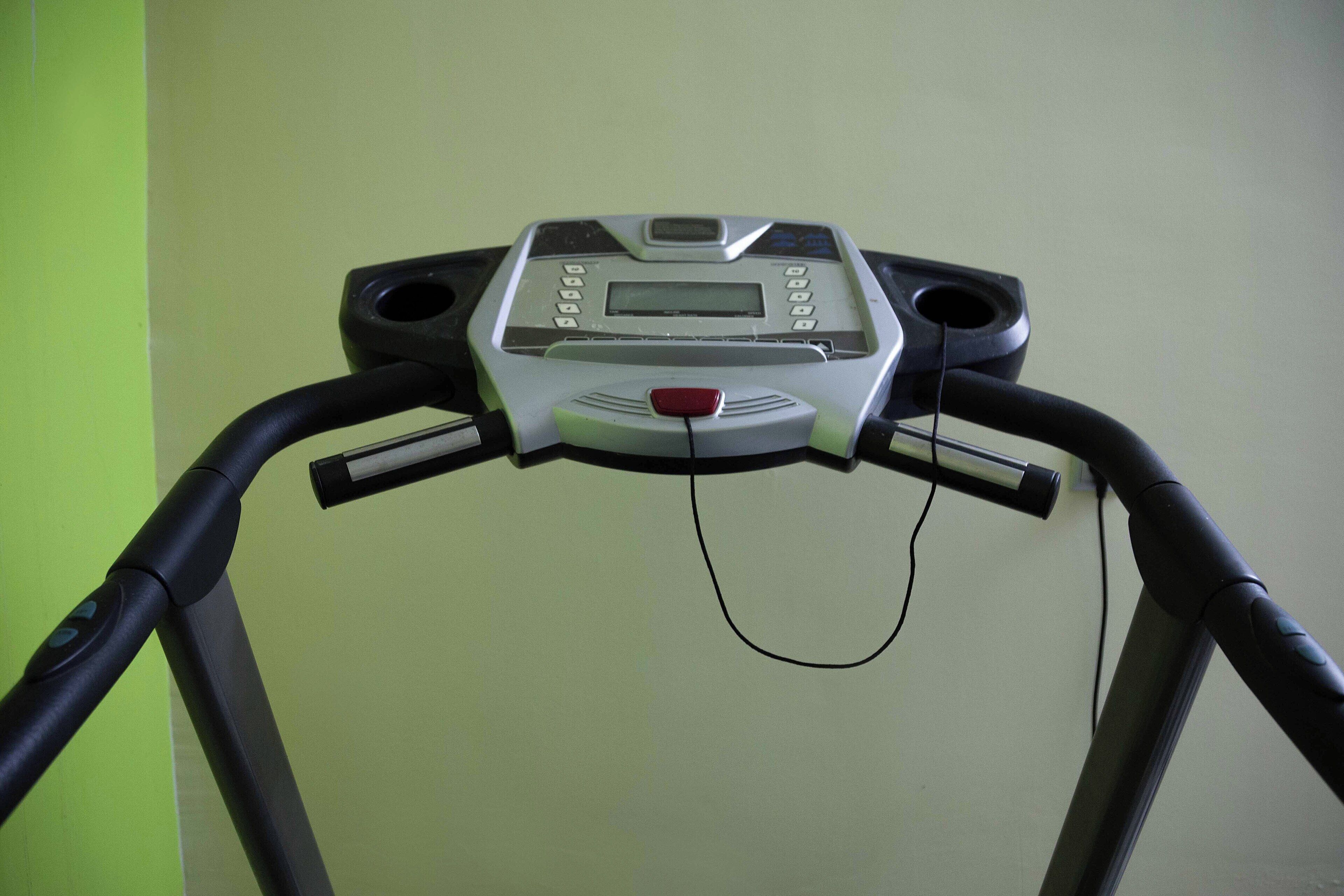 A treadmill with a digital display and control panel.