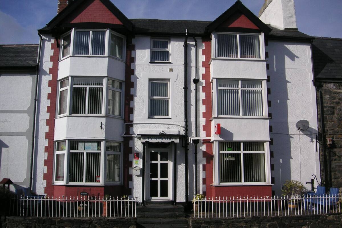 A two-story building with a white facade and red accents.