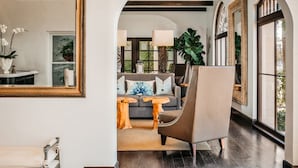 A modern living room with a sofa, armchairs, and a large mirror. - Hotel Marisol Coronado (Coronado)