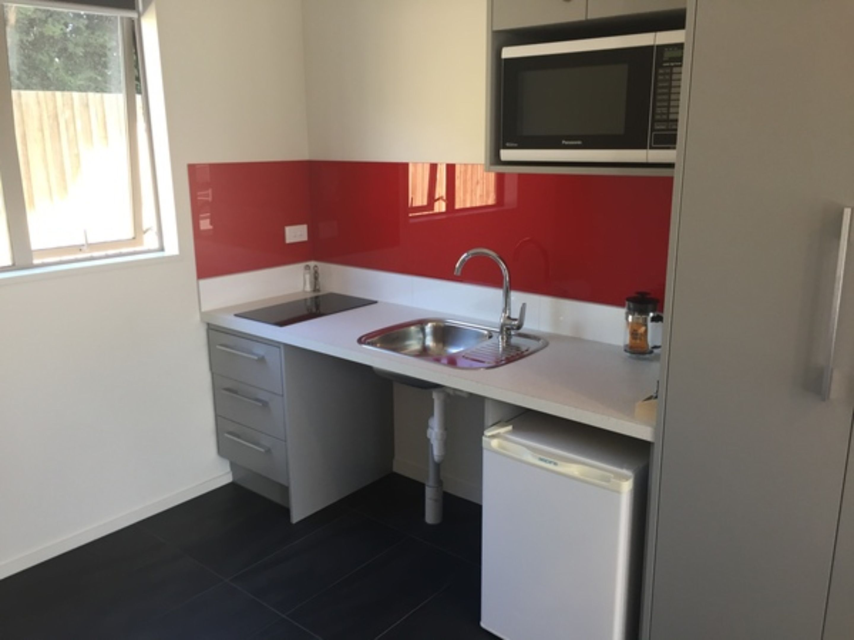 Cocina compacta con un lavaplatos, un microondas y un refrigerador.