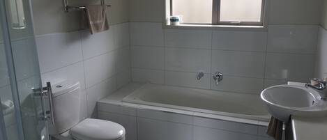 Une salle de bain comprenant des toilettes, une baignoire et un lavabo.