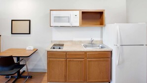 A compact kitchen with a microwave, sink, and refrigerator.
