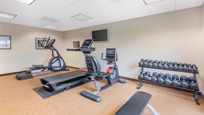 A gym with treadmills, an elliptical, a bench, and a rack of dumbbells. - Sleep Inn & Suites Devils Lake (Devils Lake)