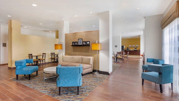 A spacious lobby with a central seating area, a reception desk, and a dining area. - Sleep Inn & Suites Devils Lake (Devils Lake)
