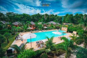 A resort with a large pool area, multiple lounge chairs, and umbrellas. - Peaceful Resort Koh Lanta (Ko Lanta)