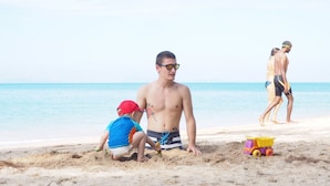 A beach scene with people playing and a toy truck on the sand. - Peaceful Resort Koh Lanta (Ko Lanta)