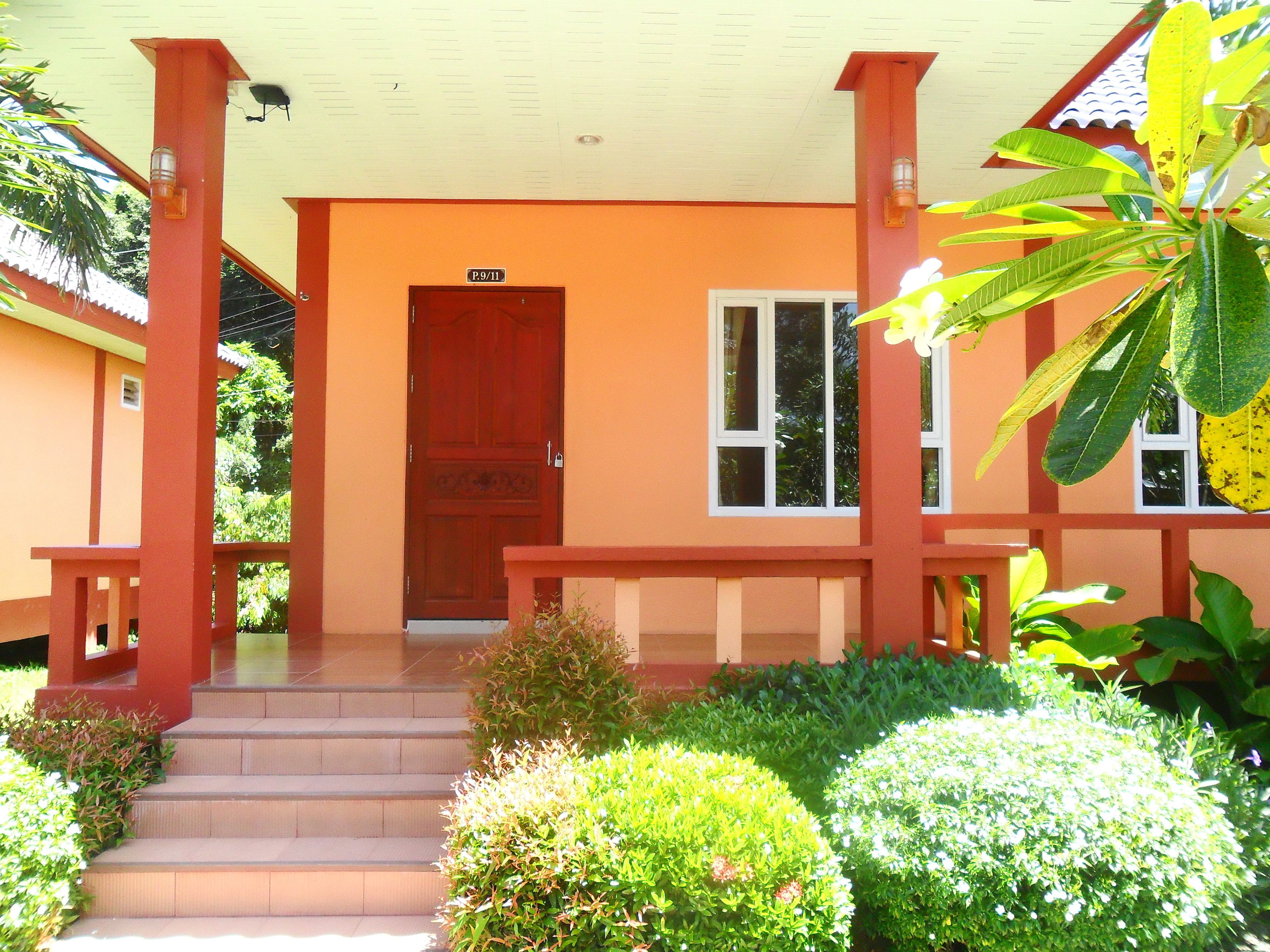 A building with a red door, a sign above it, and a staircase leading to the entrance.