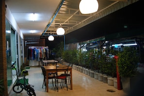 Un espace de restauration intérieur avec des tables et des chaises, des plantes en pot et un vélo.