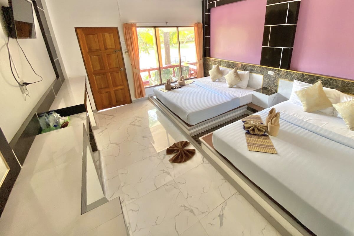 Habitación de hotel con una cama grande, baño con piso de mármol y vistas al exterior.
