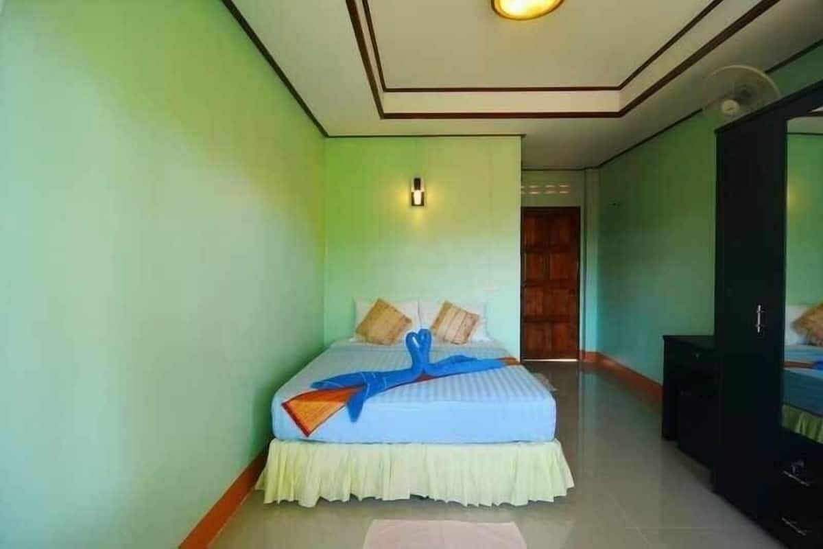 Un dormitorio ordenado con una cama, una mesita de noche y un armario.