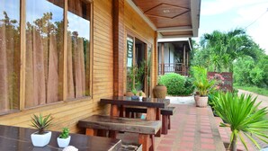 A wooden building with large windows, outdoor seating, and potted plants. -  Baan Rabieng (Ko Lanta)