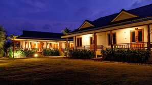 A two-story house with a well-lit front porch and a small staircase leading to the entrance. -  Baan Rabieng (Ko Lanta)