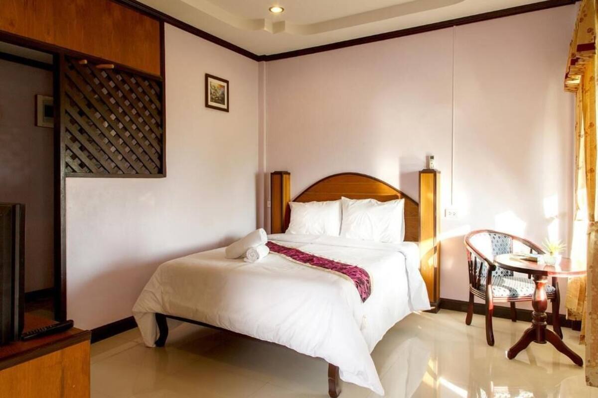 Une chambre d’hôtel avec un lit, une chaise, une table et un téléviseur.