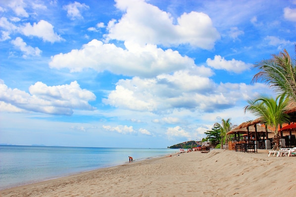 On the beach, white sand, beach umbrellas, beach towels