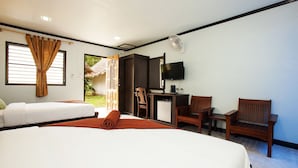 Een hotelkamer met twee bedden, een bureau met computer, een televisie en een zithoek.