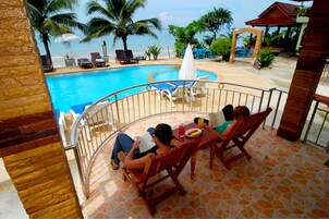 Una piscina al aire libre, sillones reclinables de piscina