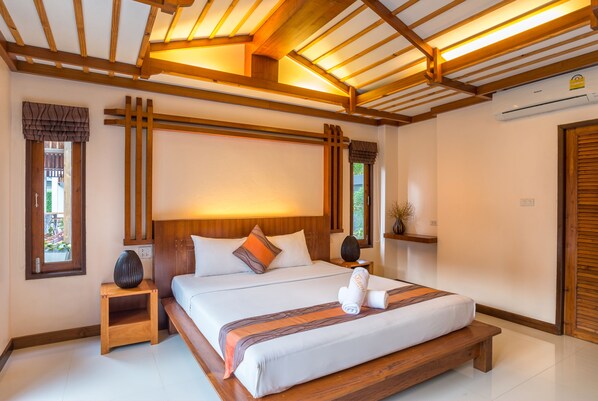 Un dormitorio amplio con una cama grande, cabecera de madera y tragaluz.