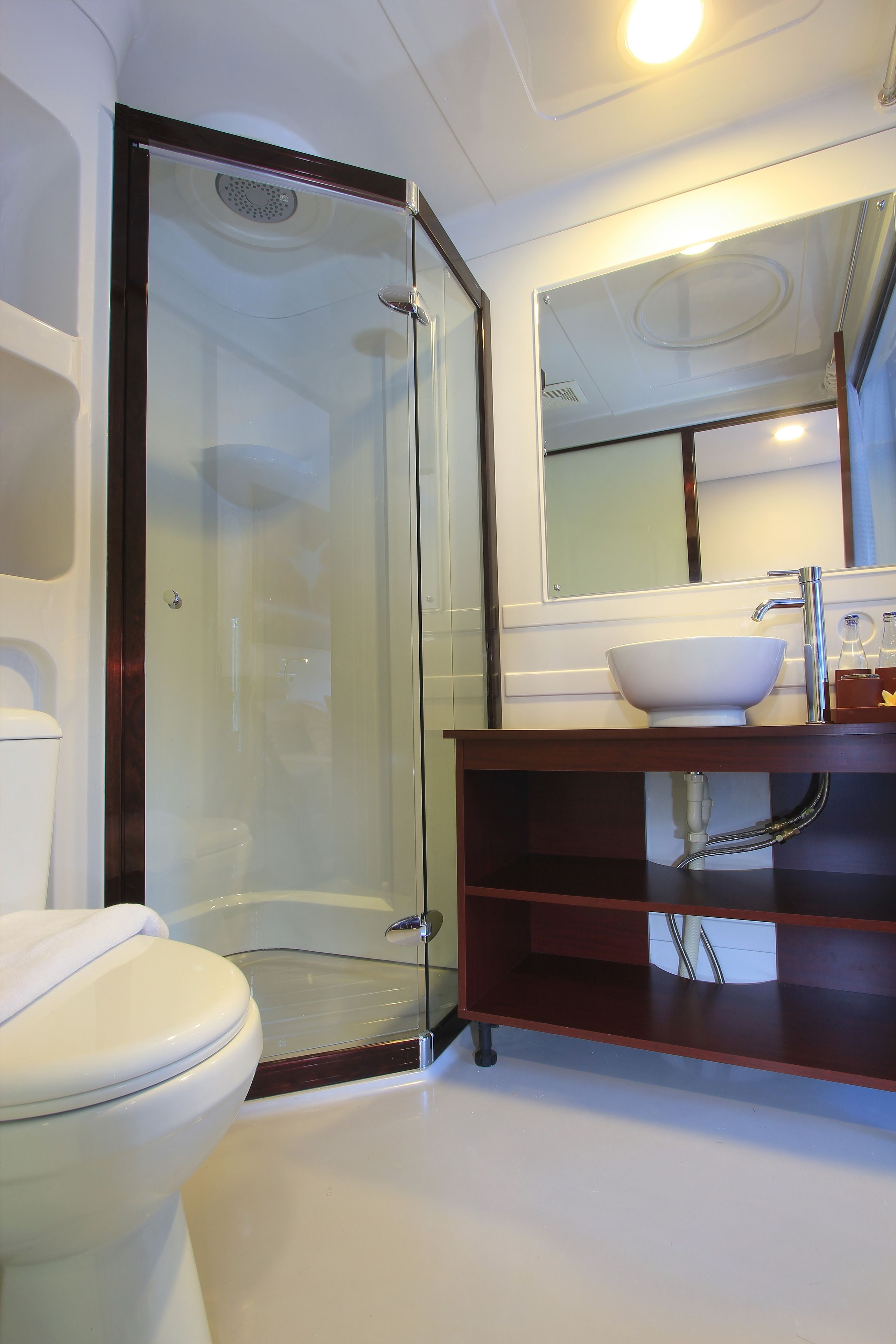 A modern bathroom with a glass-enclosed shower, a white sink, and a mirror above the sink.