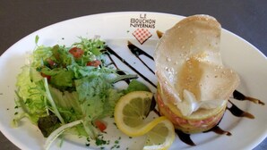 Un plato con un sándwich, ensalada y rodajas de limón.