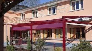 A hotel with a red awning and a sign that reads "Le Pilon Hotel Restaurant." - Hôtel CARRER Le Rhien (Ronchamp)