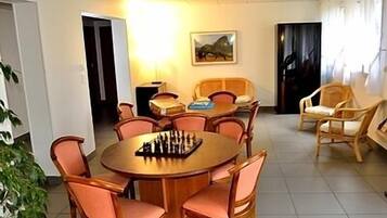 A dining area with a round table, chairs, and a chessboard.