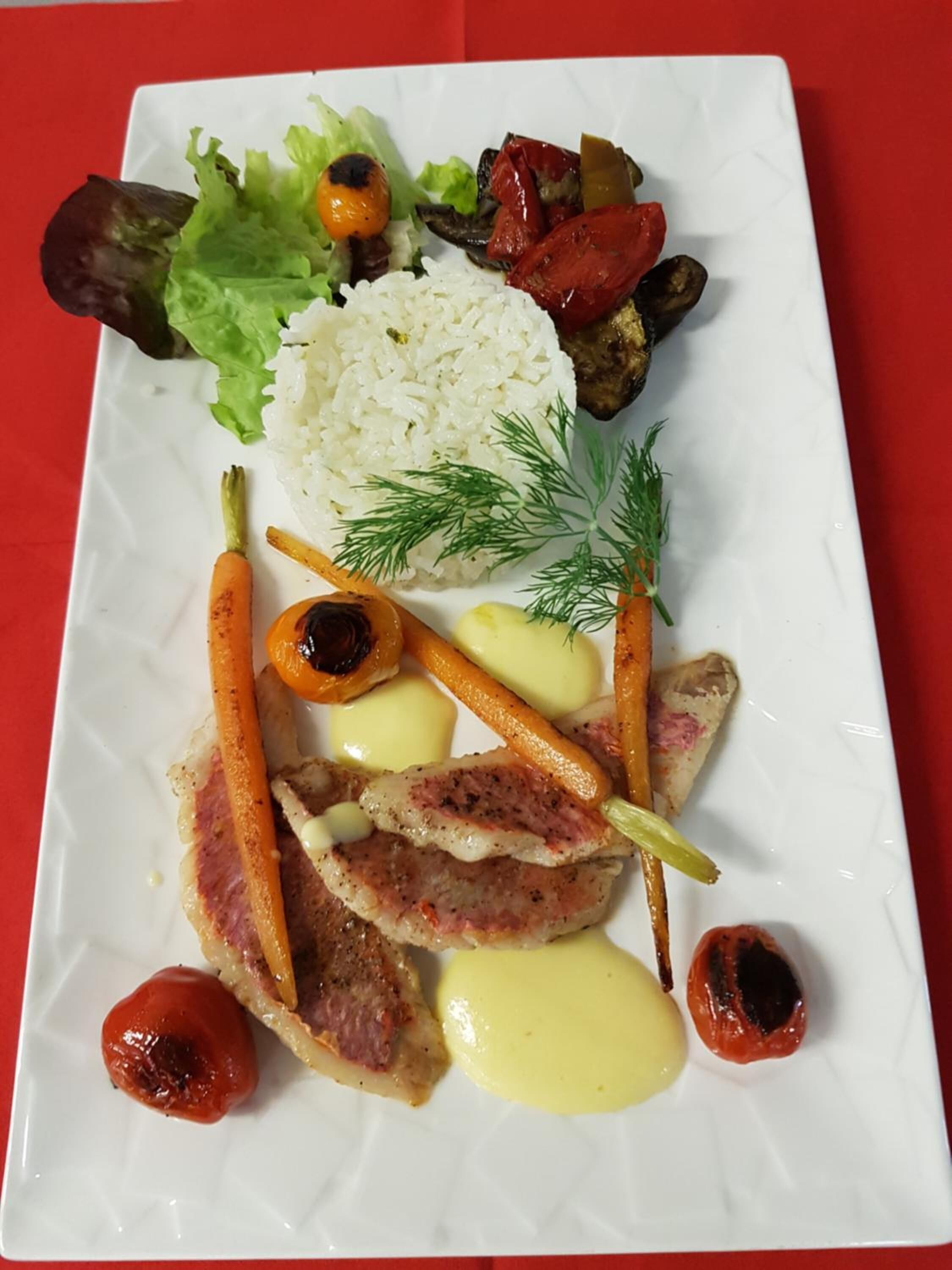 Un plato rectangular blanco con una variedad de alimentos, como arroz, verduras y carne.