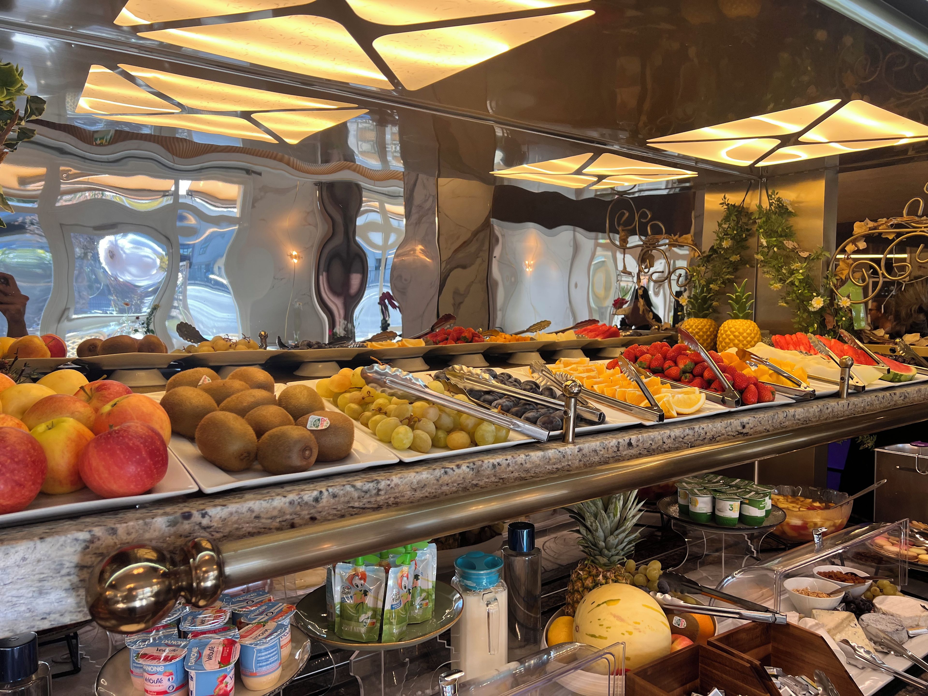 A buffet with a variety of fruits and dairy products.