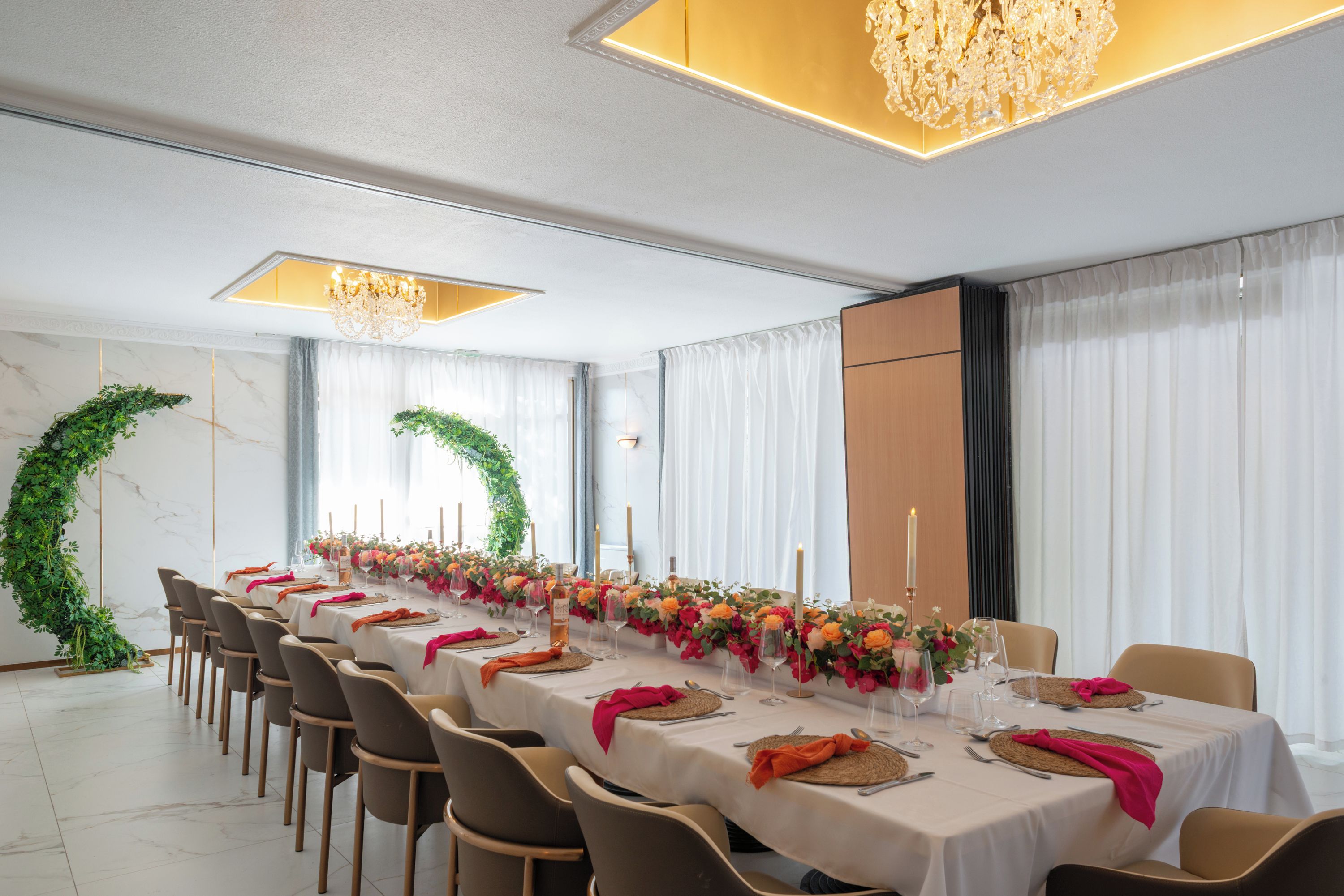 A long dining table set for a formal event, with chairs aligned on both sides.