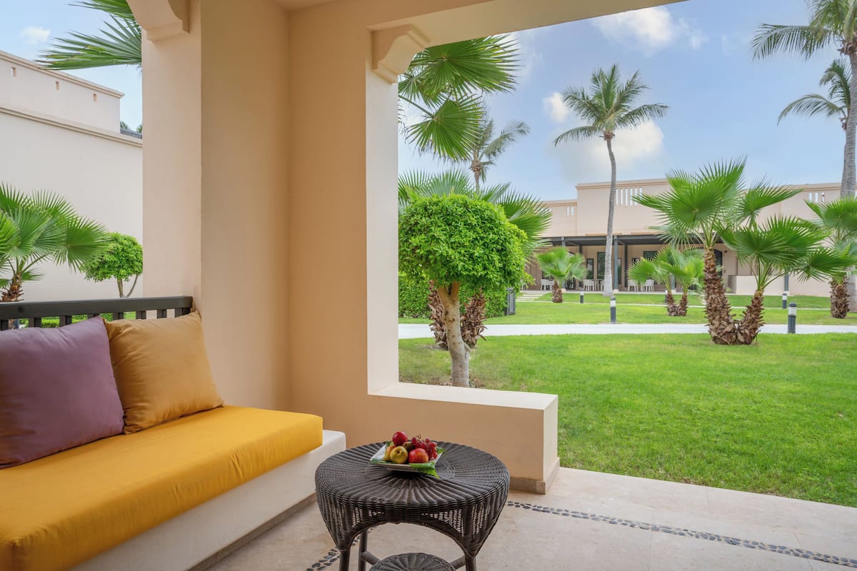 A balcony with a sofa and a small table with fruit.