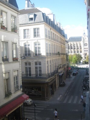 A street view with a building featuring a corner entrance, a visible storefront, and a pedestrian crossing. - Hotel du Pont neuf (Paris)