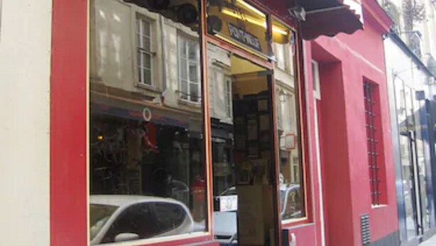 Un escaparate rojo con un amplio ventanal y un cartel que dice "HOTEL".
