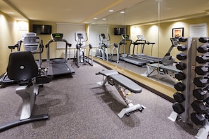A gym with treadmills, elliptical machines, a bench, and dumbbells. - Holiday Inn Express & Suites Willmar by IHG (Willmar)