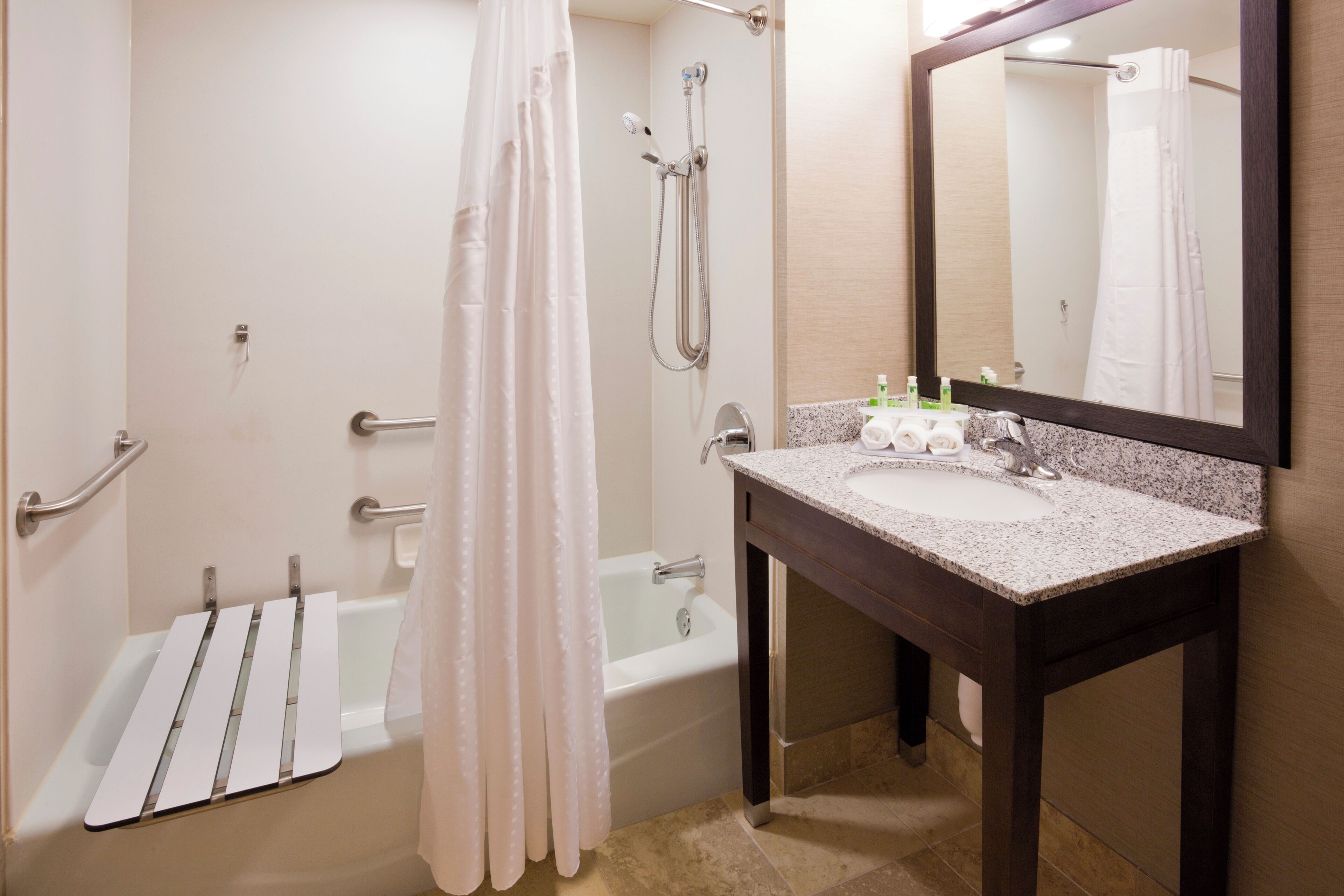 A bathroom with a bathtub, a shower, a sink, and a mirror.