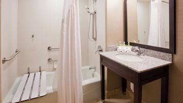 A bathroom with a bathtub, a shower, a sink, and a mirror.