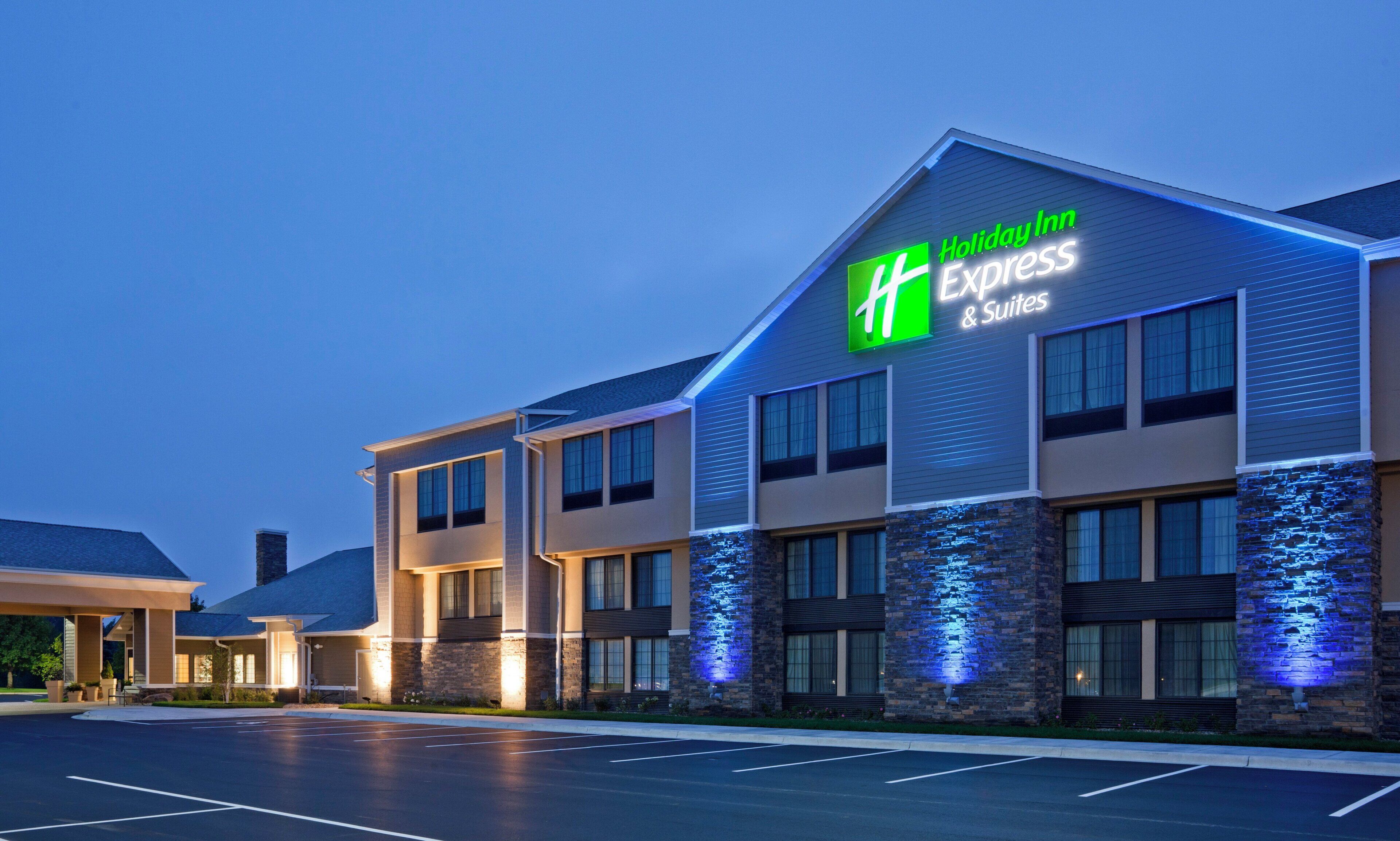 Un hôtel Holiday Inn Express & Suites au design moderne, doté d’une enseigne bien visible et d’une façade bien éclairée.