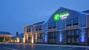 Un hôtel Holiday Inn Express & Suites au design moderne, doté d’une enseigne bien visible et d’une façade bien éclairée.