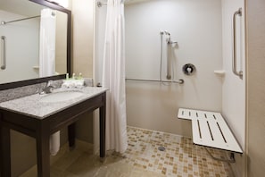 A bathroom with a sink, mirror, shower, and grab bars. - Holiday Inn Express & Suites Willmar by IHG (Willmar)