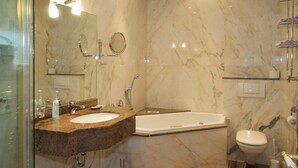 A modern bathroom with a marble vanity, a bathtub, and a toilet. - Hotel Schmidt (Hamburg)