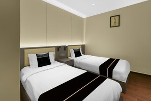 A hotel room with two beds, a nightstand, a wall-mounted light, and a framed picture. - Hotel O GHC Near Penang Street Art (George Town)