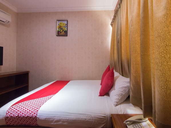 A hotel room with a bed, a telephone, a painting on the wall, and a window with curtains. - Hotel O GHC Near Penang Street Art (George Town)