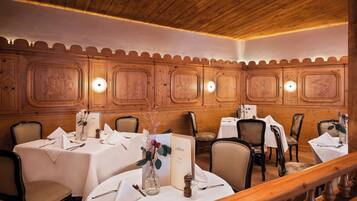 A dining area with wooden paneling and white tablecloths.