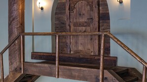 Una escalera de madera que lleva a una zona de piscina con un reloj encima.