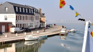 A waterfront hotel with a dock, boats, and a clear view of the water. - Hôtel du Port et des bains (Saint-Valery-sur-Somme)