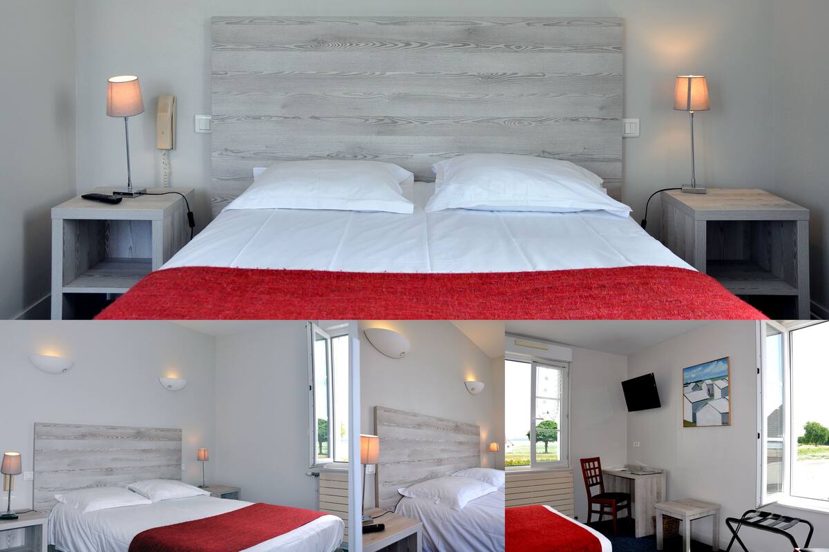 A hotel room with a bed, two bedside tables, a desk, and a chair.