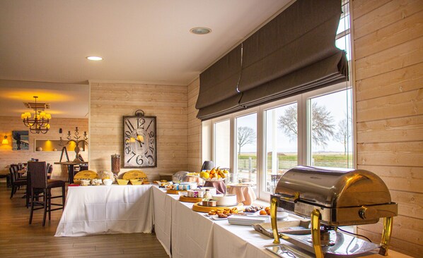 Uma área de refeições com mesa de buffet, um relógio e uma churrasqueira.