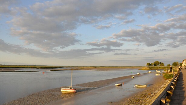 A riverside walkway with boats moored along the bank. - Hôtel du Port et des bains (Saint-Valery-sur-Somme)