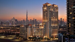Un hotel de gran altura con varios pisos, una torre central destacada y una fachada bien iluminada.