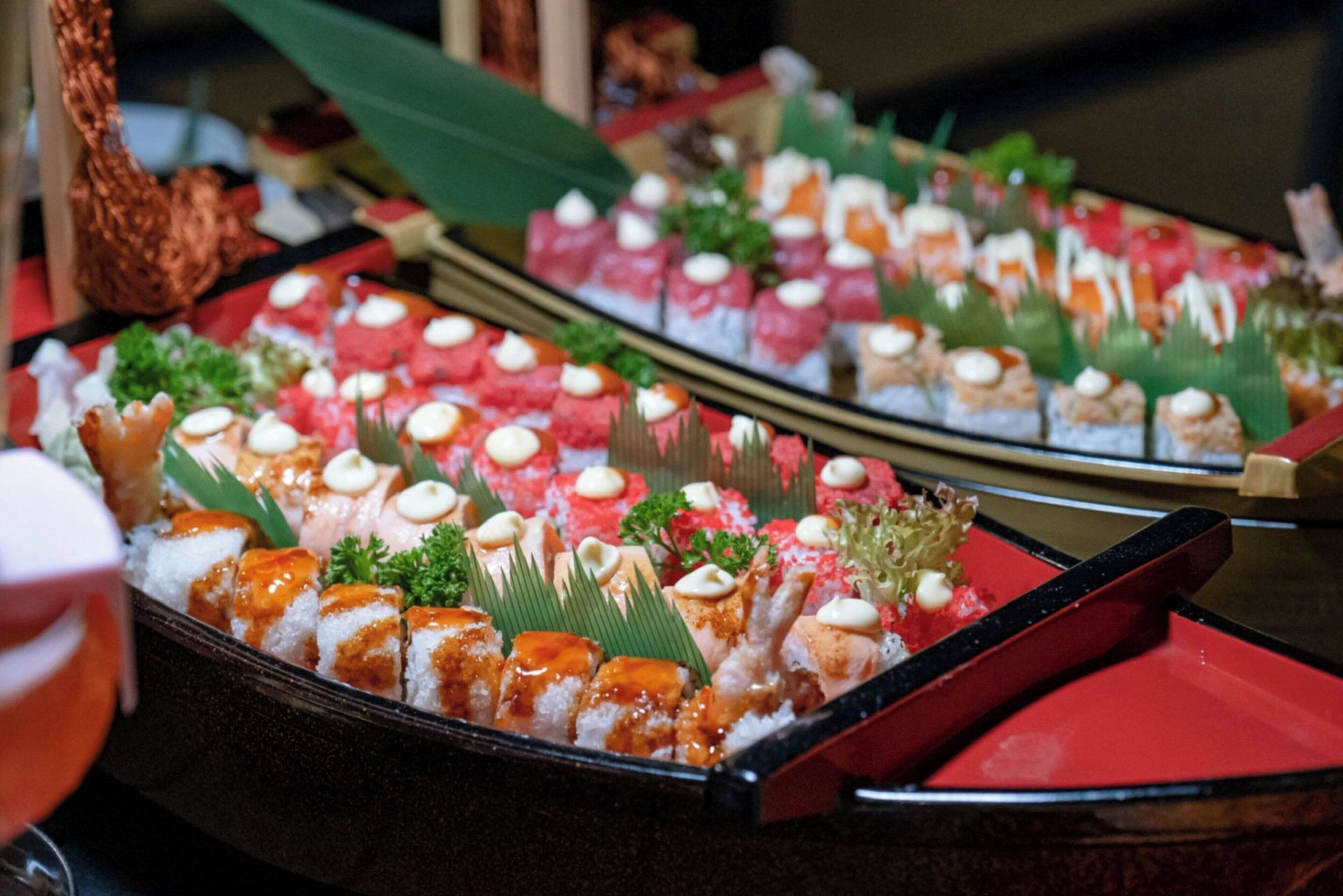 A buffet with various dishes, including sushi and other appetizers.